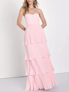 a woman is wearing a pink dress with tiered layers and a strapless top