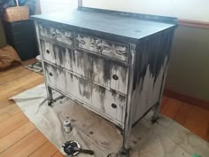 an old dresser is being painted with black and white paint