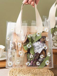 a person holding a clear bag with white flowers on it and the words best wishes