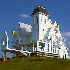 a large white house sitting on top of a lush green hillside