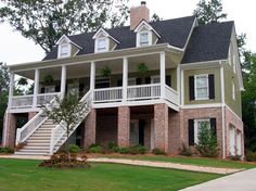 a two story house with white balconies and black shutters on the front