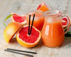 grapefruit, orange juice and strawberries on a wooden table with chopsticks