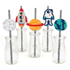 an assortment of cupcake toppers and straws in glass vases with space theme