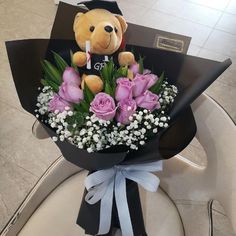 a teddy bear sitting on top of a bouquet of flowers