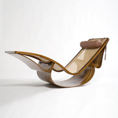 a wooden chair that is shaped like a wave with a leather seat and arm rest