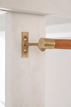 a wooden handle on the side of a white wall