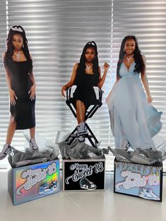 three barbie dolls sitting on top of boxes