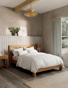 a bed with white sheets and pillows in a bedroom next to a large window,