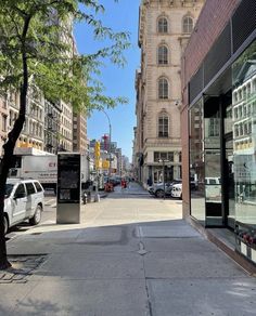 an empty city street with cars parked on the side