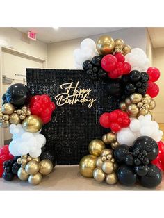 a happy birthday balloon arch with red, white and black balloons