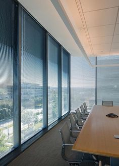 an empty conference room with large windows overlooking the city