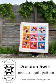 a person holding up a quilt in front of a wooden fence with the words, dresden swirl modern quilt pattern