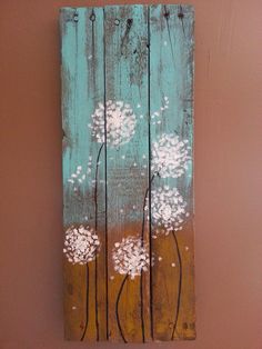 a wooden sign with white flowers painted on it