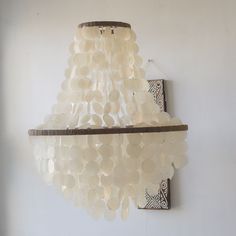 a chandelier made out of plastic bottles hanging from a wall next to a mirror