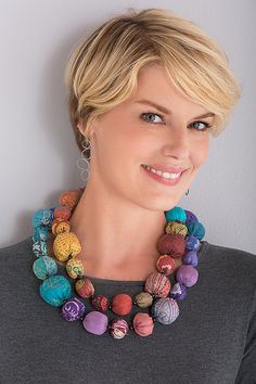 a woman with blonde hair wearing a multicolored necklace