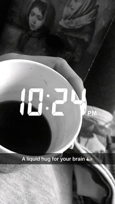 a person holding a coffee cup with the time 11 29 pm on it's screen