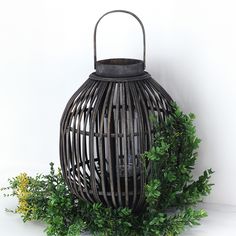 an old fashioned lantern is surrounded by greenery