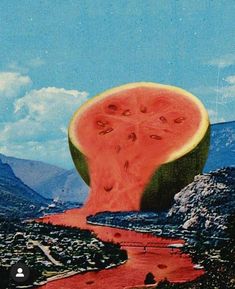 a piece of watermelon is floating in the air over a river and mountains