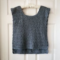 a crocheted top hanging on a door