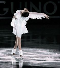 a woman in white is performing on the ice