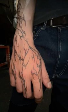 a man's hand with tattoos on it, and his fingers are covered in barbed wire