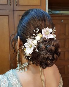 a woman with flowers in her hair is wearing a flowery headpiece on her wedding day