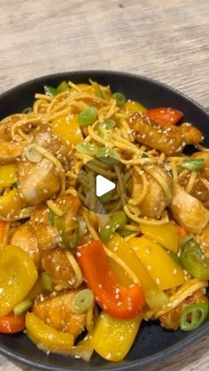 a black bowl filled with noodles and vegetables