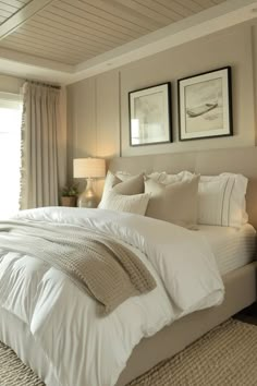 a large bed sitting in a bedroom next to two framed pictures