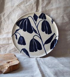 a blue and white plate sitting on top of a table next to a piece of wood