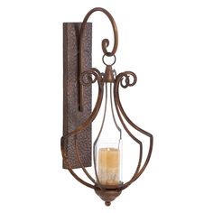 an old fashioned wall light with a candle in the center and scrolled design on it