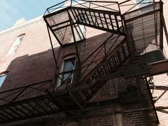 an old fire escape on the side of a brick building with metal bars attached to it