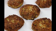 four crab cakes are on a white plate