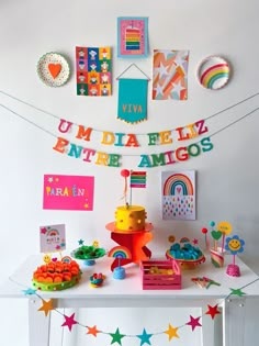 a table topped with lots of colorful items and paper garlands on top of it