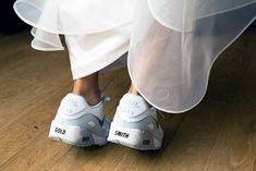 a close up of a person's shoes on a wooden floor