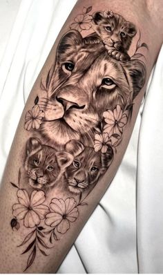 a lion and cubs tattoo on the left arm, with flowers around it's neck