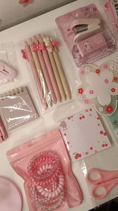 the contents of a crafting kit are laid out on a white table with pink accessories