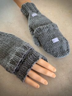 two knitted mittens sitting on top of a wooden table