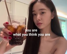 a woman holding up a glass filled with drinks