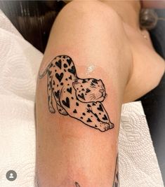 a black and white tattoo of a cheetah with hearts on it's arm