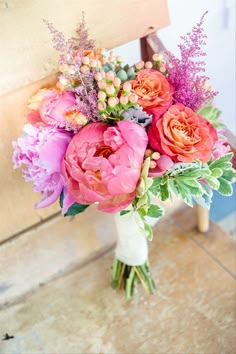 a bouquet of flowers sitting on top of a wooden chair