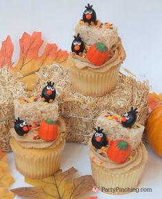 cupcakes decorated with fake pumpkins and hay are sitting on hay bales