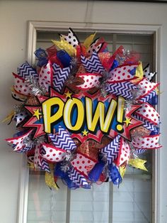 a wreath with the word pow on it is hanging from a front door, decorated with red, white and blue streamers