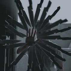 a person holding their hands up in front of a clock with many knives sticking out of it