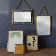 three framed pictures hanging on a wall next to each other with numbers and letters below them