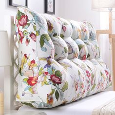 an upholstered headboard with flowers on it in front of a white wall