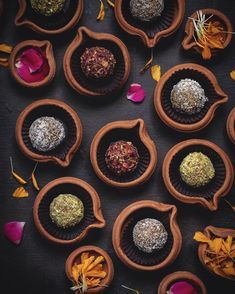 chocolate truffles in wooden bowls with flowers on the side and petals around them