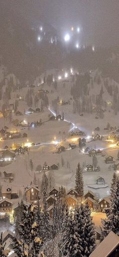 a ski resort at night with snow on the ground and lights in the sky above it