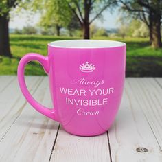 a pink coffee mug with the words always wear your invisible cream on it sitting on a wooden table