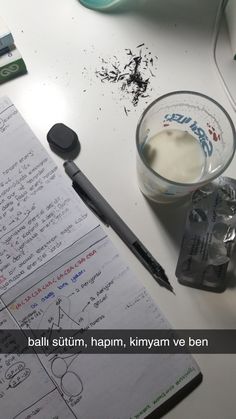 a notepad with writing on it next to a cup of coffee and a pen