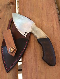 a knife and sheath sitting on top of a wooden table next to a knife holder